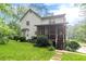 Exterior angle of home with green lawn, mature trees, and a charming screened-in porch at 5609 Twin Oak Dr, Douglasville, GA 30135