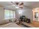 Cozy upstairs living room with ceiling fan, comfortable couch, desk with computer monitors, and an exterior-facing window at 5609 Twin Oak Dr, Douglasville, GA 30135