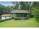 Charming green home with a cozy screened-in porch and lush, landscaped front yard offering great curb appeal at 3743 Wyntuck Nw Cir, Kennesaw, GA 30152