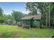 Charming green home with a cozy screened-in porch and lush, landscaped yard surrounded by mature trees at 3743 Wyntuck Nw Cir, Kennesaw, GA 30152