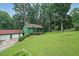 Quaint green home featuring a screened front porch, a separate two-car garage, and a well-manicured lawn at 3743 Wyntuck Nw Cir, Kennesaw, GA 30152