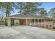 Charming brick home with a large carport and expansive driveway, nestled amongst mature trees at 4089 Menlo Dr, Tucker, GA 30084