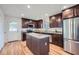 Modern kitchen with stainless steel appliances, granite countertops, a center island, and hardwood floors at 4089 Menlo Dr, Tucker, GA 30084