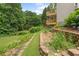 A landscaped backyard featuring a stone wall, multiple decks, and lush greenery at 4987 Day Lily Nw Way, Acworth, GA 30102