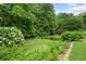 Well-maintained lawn and garden, surrounded by lush greenery and mature trees, providing a serene backyard at 4987 Day Lily Nw Way, Acworth, GA 30102