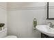 A half-bathroom with wainscotting, a dark vanity, and a white sink at 4987 Day Lily Nw Way, Acworth, GA 30102
