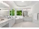 Bright bathroom featuring double vanities, a soaking tub with a garden view, and neutral tile floors at 4987 Day Lily Nw Way, Acworth, GA 30102