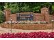 Welcoming brick entrance to Chestnut Hill community, adorned with flowers and American flags at 4987 Day Lily Nw Way, Acworth, GA 30102