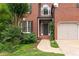 Elegant brick home entrance with a well-lit doorway and manicured greenery at 4987 Day Lily Nw Way, Acworth, GA 30102