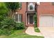 Close-up of a brick home's entryway and garage with meticulous landscaping at 4987 Day Lily Nw Way, Acworth, GA 30102