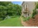 Home exterior featuring a well-manicured lawn, brick retaining wall, and garden with lush foliage at 4987 Day Lily Nw Way, Acworth, GA 30102