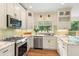Bright kitchen features stainless steel appliances, granite countertops, and white cabinets at 4987 Day Lily Nw Way, Acworth, GA 30102