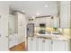 Well-lit kitchen showcases white cabinets, granite countertops, stainless steel appliances, and hardwood floors at 4987 Day Lily Nw Way, Acworth, GA 30102