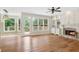 Bright living room featuring hardwood floors, fireplace, ceiling fan, and built-in cabinets with shelves at 4987 Day Lily Nw Way, Acworth, GA 30102
