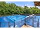 Exterior view of a tennis court surrounded by a fence and tall trees at 4987 Day Lily Nw Way, Acworth, GA 30102