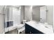 Bathroom featuring a shower/tub combo with a blue and white curtain, toilet, blue vanity, and a decorative soap dispenser at 6313 Shoreland Cir, Buford, GA 30518