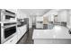 Bright kitchen featuring stainless steel appliances, white cabinets, and gray backsplash at 6313 Shoreland Cir, Buford, GA 30518
