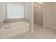 Bathroom featuring tiled shower, soaker tub, and tiled floors at 2870 Prestwood Dr, Cumming, GA 30040