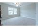 Carpeted bedroom provides a bright space with a ceiling fan and natural light from a large window at 2870 Prestwood Dr, Cumming, GA 30040