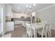 Well-lit white kitchen features stainless steel appliances, an island, and a dining area with a decorative chandelier at 2870 Prestwood Dr, Cumming, GA 30040