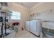 Well-lit laundry room featuring a washer, dryer, sink, storage shelves, and tiled floor for efficient chores at 2870 Prestwood Dr, Cumming, GA 30040
