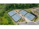 Multiple tennis courts with a parking area, surrounded by lush trees and greenery from above at 2870 Prestwood Dr, Cumming, GA 30040