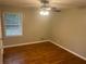 Neutral bedroom featuring hardwood floors, a ceiling fan, and window for natural light at 4902 Pine Hill E Ct, Stone Mountain, GA 30088