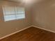 Simple bedroom featuring hardwood floors, neutral walls, and a bright window at 4902 Pine Hill E Ct, Stone Mountain, GA 30088