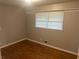 Comfortable bedroom showcasing hardwood floors, neutral walls, and a bright window at 4902 Pine Hill E Ct, Stone Mountain, GA 30088