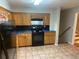 Functional kitchen with oak cabinets, black appliances, and tile backsplash at 4902 Pine Hill E Ct, Stone Mountain, GA 30088