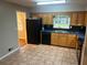 Functional kitchen featuring black appliances, oak cabinets, and a spacious layout at 4902 Pine Hill E Ct, Stone Mountain, GA 30088