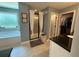 Bright bathroom featuring a glass shower, soaking tub, and black countertops at 8340 Nolandwood Ln, Villa Rica, GA 30180