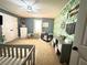 Charming Bedroom featuring a crib, leafy wallpaper and plenty of storage for baby essentials at 8340 Nolandwood Ln, Villa Rica, GA 30180