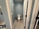 Powder room with neutral colors, toilet and tiled floors at 8340 Nolandwood Ln, Villa Rica, GA 30180