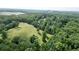 Wide aerial view showcasing the home's wooded surroundings with a lake in the distance at 8872 Conners Rd, Villa Rica, GA 30180