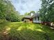 Spacious backyard featuring lush green grass, screened-in porch, and mature trees at 8872 Conners Rd, Villa Rica, GA 30180