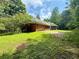 Side view of a brick home with a garage and screen porch, surrounded by green grass at 8872 Conners Rd, Villa Rica, GA 30180