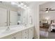 Bright bathroom with a double vanity, white cabinets, mirrors, and an adjoining bedroom at 1408 Chloe Dr, Lawrenceville, GA 30043