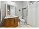 Bathroom with framed mirror, wooden cabinets, tile floor, commode and shower with curtain at 1408 Chloe Dr, Lawrenceville, GA 30043