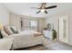 Bright bedroom features a large window, ceiling fan, matching furniture and plush carpet, with warm, neutral paint at 1408 Chloe Dr, Lawrenceville, GA 30043