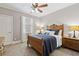Cozy bedroom with a wooden bed frame, a ceiling fan, and a window with blinds at 1408 Chloe Dr, Lawrenceville, GA 30043