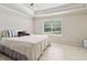 Bedroom featuring large window, tile flooring, tray ceiling, and ceiling fan at 1408 Chloe Dr, Lawrenceville, GA 30043