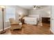 Light-filled bedroom with a ceiling fan, hardwood floors, an accent chair, and a cozy, neutral color palette at 1408 Chloe Dr, Lawrenceville, GA 30043