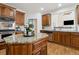 Close-up of kitchen island with granite countertops and seating area, next to stainless appliances at 1408 Chloe Dr, Lawrenceville, GA 30043