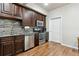Kitchen with stainless appliances, granite counter tops, dark cabinets, mosaic tile backsplash, and wood floors at 1408 Chloe Dr, Lawrenceville, GA 30043