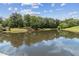 Scenic lake view reflecting a bright blue sky, surrounded by mature trees and grassy banks, offering a serene natural setting at 1408 Chloe Dr, Lawrenceville, GA 30043