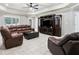 Large living room with leather furniture, a coffered ceiling, tile flooring, and a decorative entertainment center at 1408 Chloe Dr, Lawrenceville, GA 30043