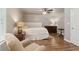 Cozy bedroom with hardwood floors, chair, side tables, lamps, ceiling fan and neutral paint at 1408 Chloe Dr, Lawrenceville, GA 30043