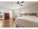 Relaxing bedroom with ceiling fan, wood floors, dresser and bathroom access at 1408 Chloe Dr, Lawrenceville, GA 30043