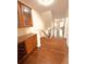 Inviting hallway with wood floors, a staircase, and a built-in wooden cabinet with granite countertop at 4438 Lassen Ct, Suwanee, GA 30024
